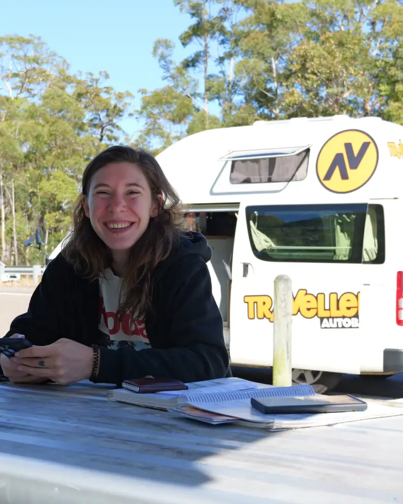 van en arrière plan et Margo qui sourie au premier plan